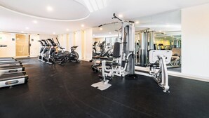 Ein Fitnessstudio mit Laufbändern, Crosstrainern und Krafttrainingsgeräten.