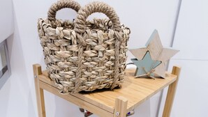 Une étagère en bois avec des paniers en osier et une étoile décorative en bois.