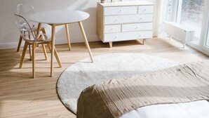 Une chambre à coucher avec un lit, une télévision, une commode, une chaise et une fenêtre.