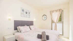 A bedroom with a bed, bedside table, wall-mounted light, window with curtains, and a wall-mounted mirror. - Incredible Sea Views – 50 m from Cala Millor Beach (Cala Millor)
