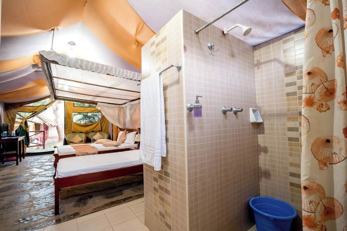 A room with a bed, a shower, and a view of the outside.
