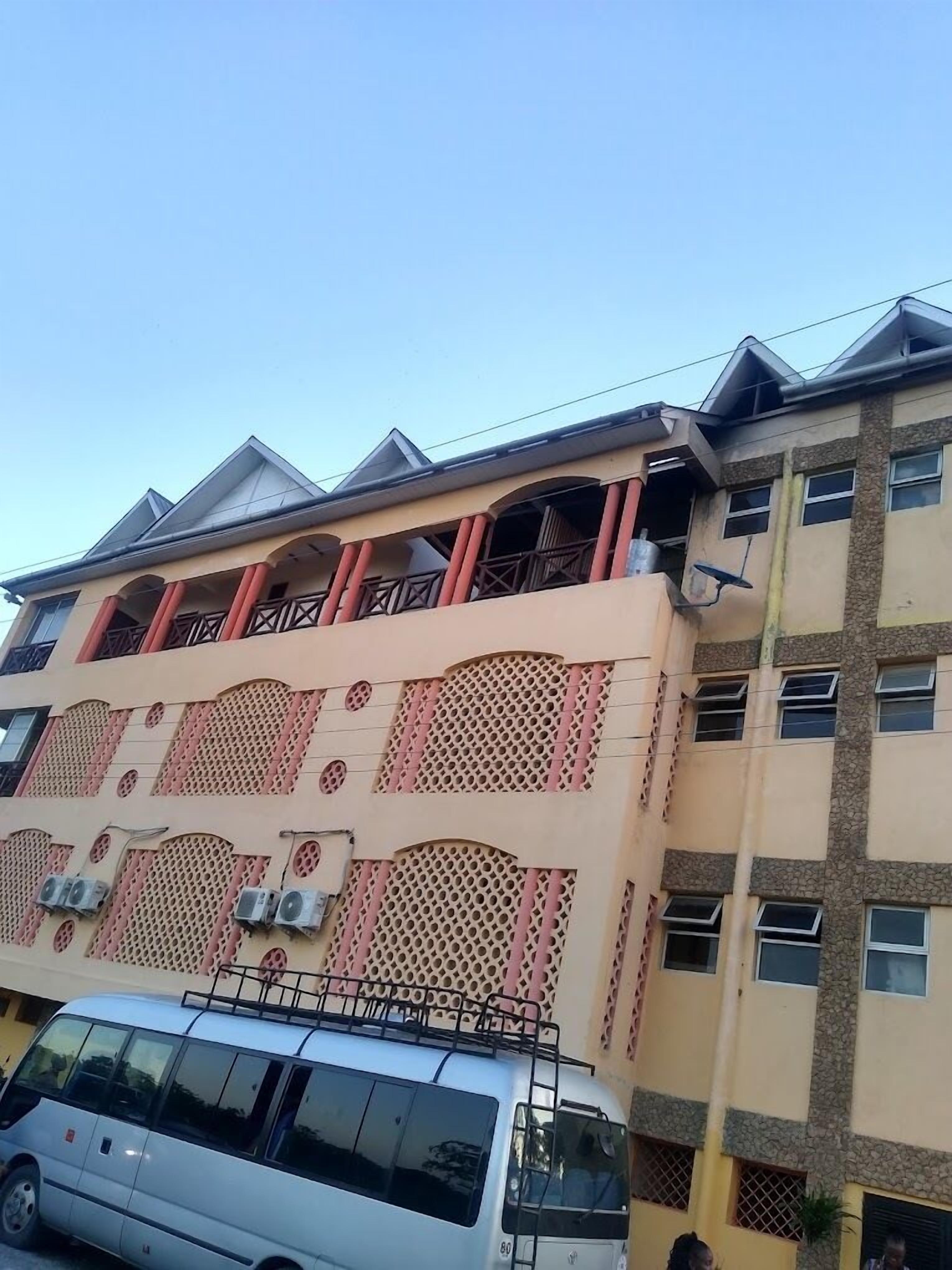 A multi-story building with a distinctive facade featuring a series of arched openings and a patterned design.