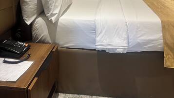 Une chambre d’hôtel équipée d’un lit, d’une table de chevet et d’un appareil de climatisation.
