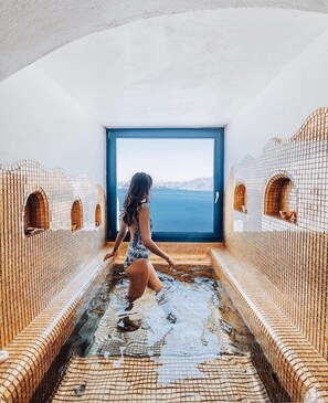 Una mujer en una bañera con vista al mar.