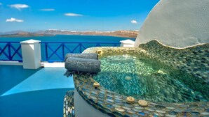 A sunlit outdoor hot tub with a clear view of the sea and distant mountains. - Althene Suite, Divine Sea and Caldera Views,Furnished Balcony, Indoor Jacuzzi (Santorini)