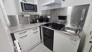 A modern kitchen with stainless steel appliances, a microwave, a coffee maker, and a dishwasher. - Maisonnette Grande Hauteur Near Paris & Stade De France (Drancy)