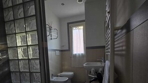 A bathroom with a toilet, bidet, sink, and a shower area. - How to Grandparents' House Narni (Umbria)