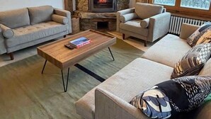 Ein gemütliches Wohnzimmer mit einem Kamin aus Stein, zwei Sofas und einem Couchtisch.