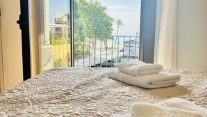 Ett hotellrum med en säng, utsikt över omgivningarna och ett fönster med gardiner.