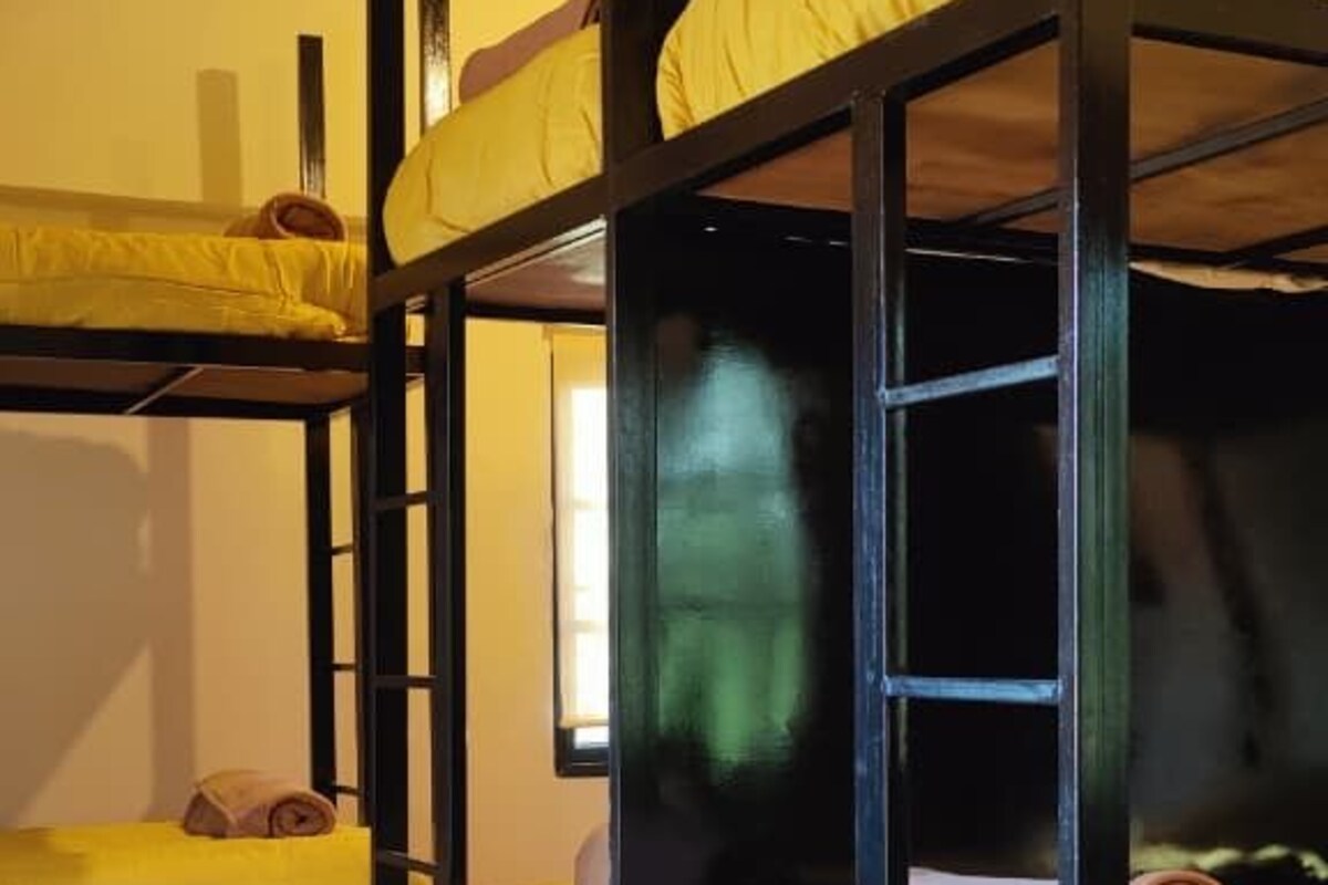 A bunk bed room with a tiled floor and a wooden ceiling.