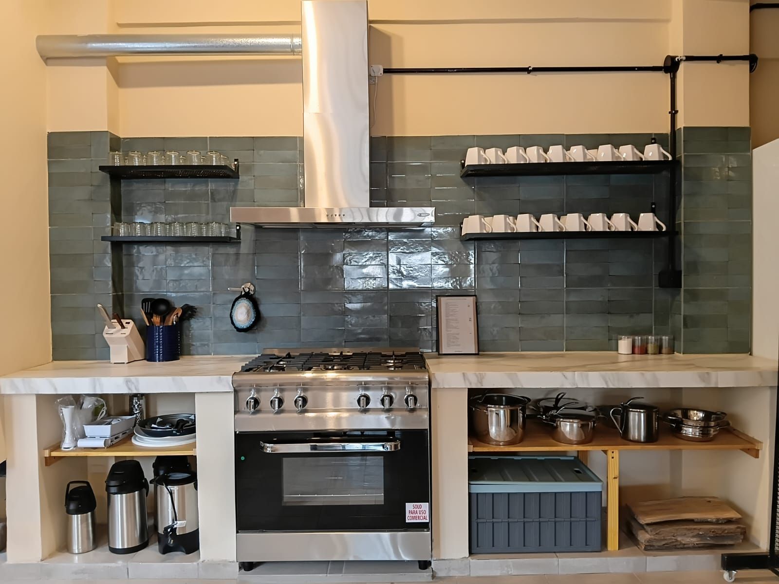 Una cocina equipada con estufa a gas, horno y diversos utensilios y electrodomésticos.