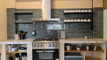 Una cocina equipada con estufa a gas, horno y diversos utensilios y electrodomésticos.