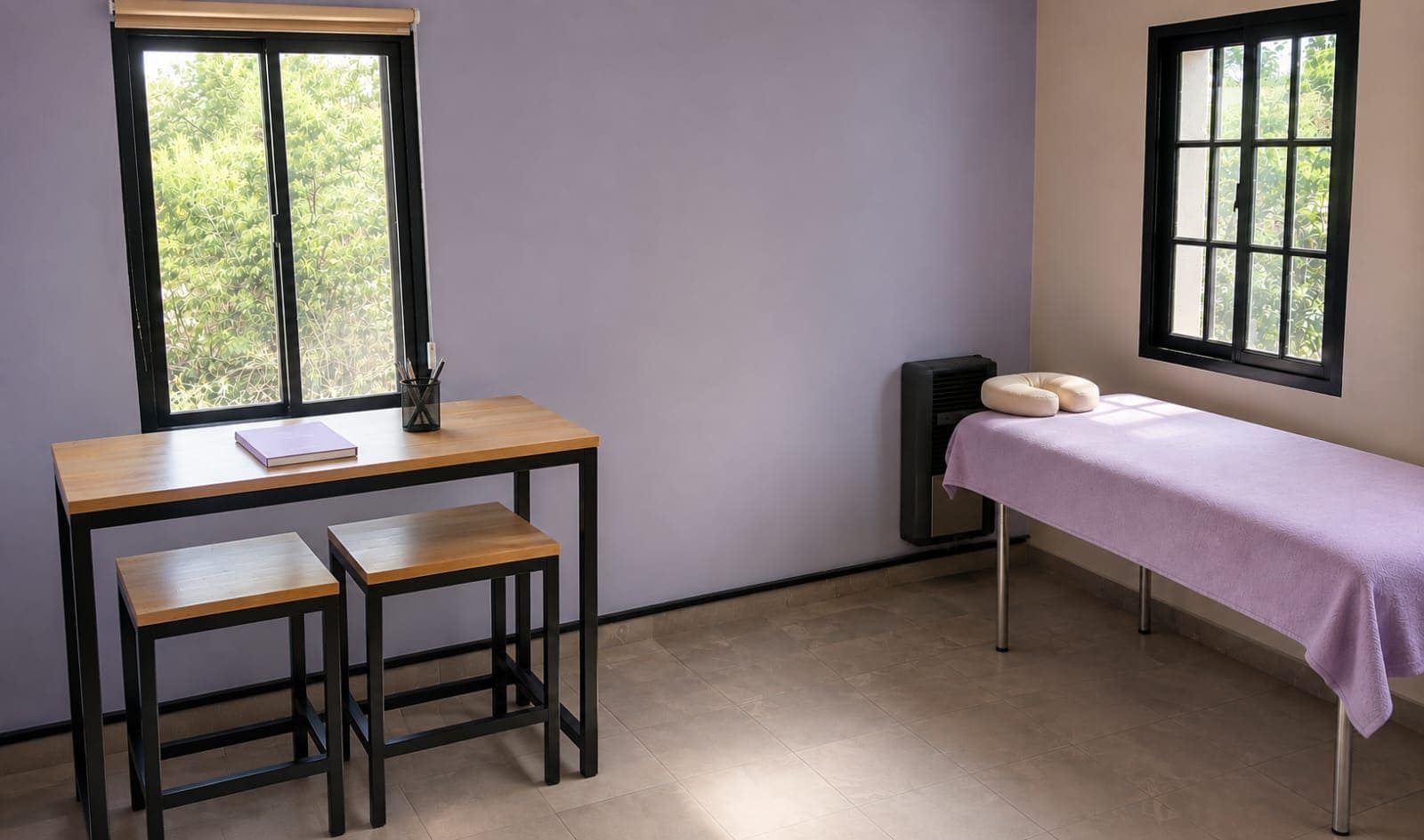 Una habitación con un escritorio, dos sillas, una mesa con cojín, un altavoz y dos ventanas.