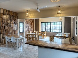 Una cocina amplia con pared de piedra, muebles de madera y ventanas grandes.