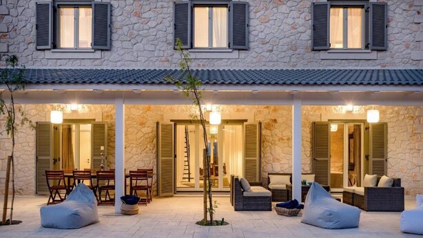 A stone building with a covered patio area featuring outdoor seating and a dining table. - Villa Melyssaia, Private Pool and Garden, Spacious Furnished Terrace, Zakynthos (Zakynthos)