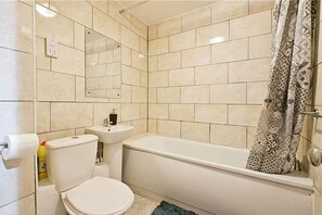 A bathroom with a toilet, sink, and bathtub. - Apartment - Sleeps 5 - Private Garden (London)