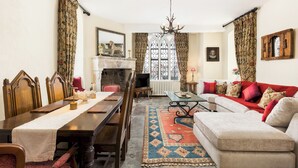 Un salon traditionnel avec une cheminée, des meubles en bois et un tapis à motifs.