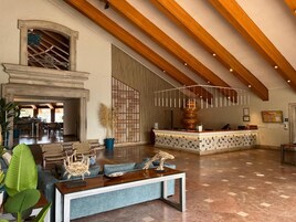 Un amplio vestíbulo con mostrador de recepción, zona de estar y chimenea.