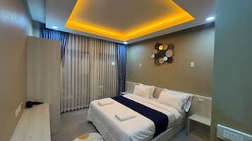 A modern bedroom with a bed, bedside tables, a headboard, a wall-mounted light fixture, and a decorative wall piece.