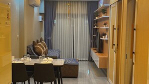 A hotel room with a dining area, a ceiling fan, a sofa, a coffee table, and a wooden wardrobe. - Room-luxury Boutique Pool Villa Ao Nang (Krabi)