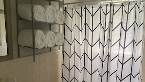Un baño con inodoro, lavamanos y toallero.