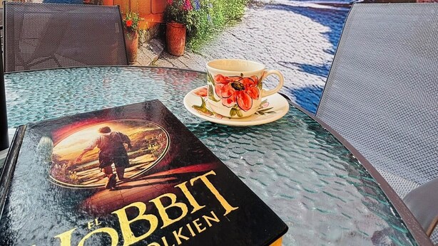 A book titled 'El Hobbit' by J.R.R. Tolkien placed on a glass table. - Hostal Capullo de seda (Zapatoca)