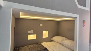 A bunk bed with a headboard that has integrated lighting. - Hostal Capullo de seda (Zapatoca)