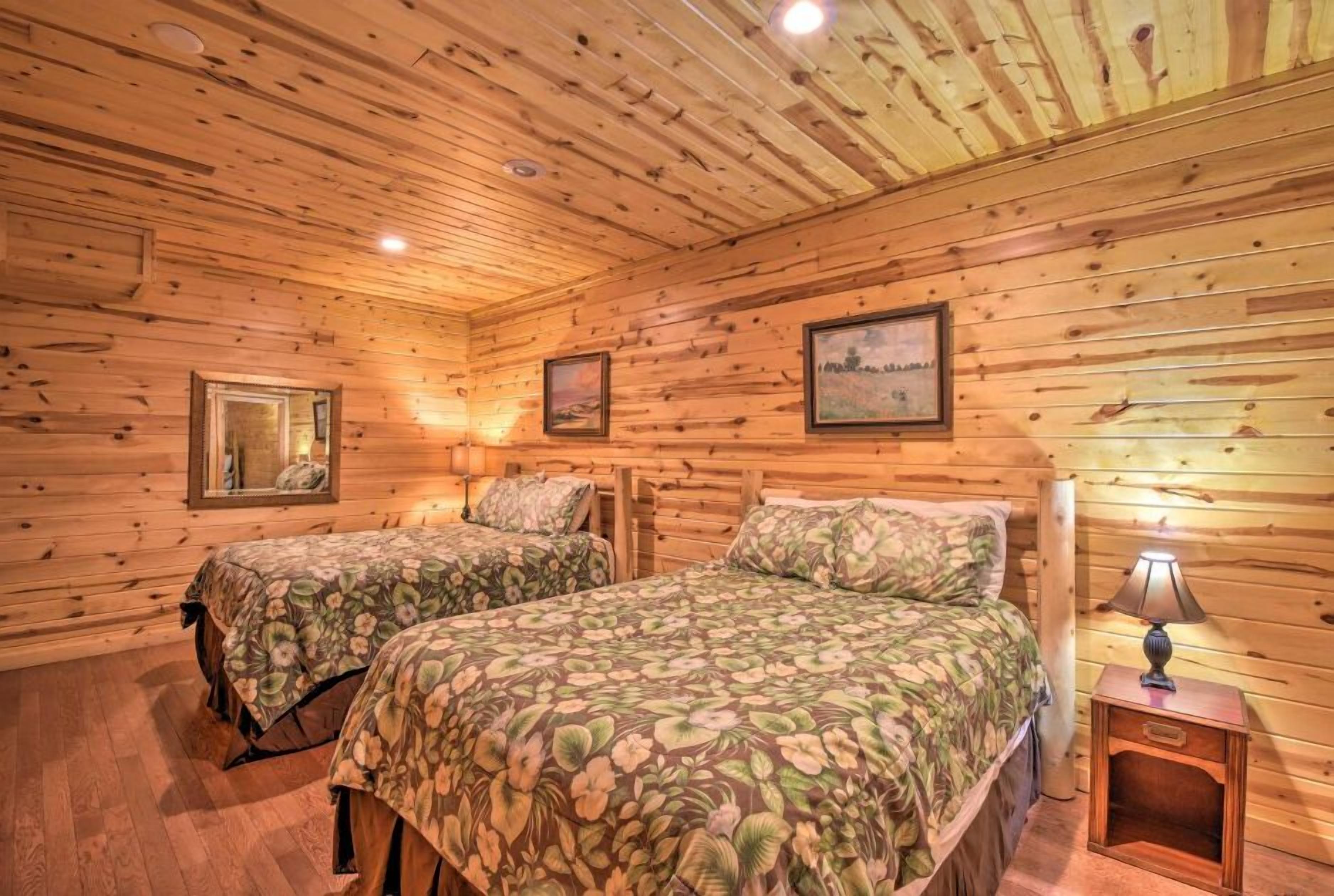 Een houten kamer met twee bedden, houten wanden en plafond, en lijstwerken aan de muur.
