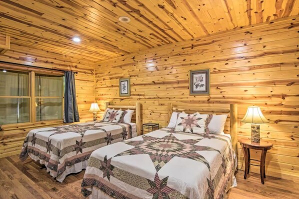 A log cabin room with two beds, wooden walls, and a large window with curtains. - Outlook Cabin! Explore N Ga near Helen! (Clarkesville)