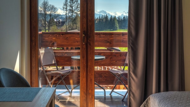 A room with a view of a wooden deck and mountains. - PRZY TERMACH - Pokoje Apartamenty Domki (Szaflary)