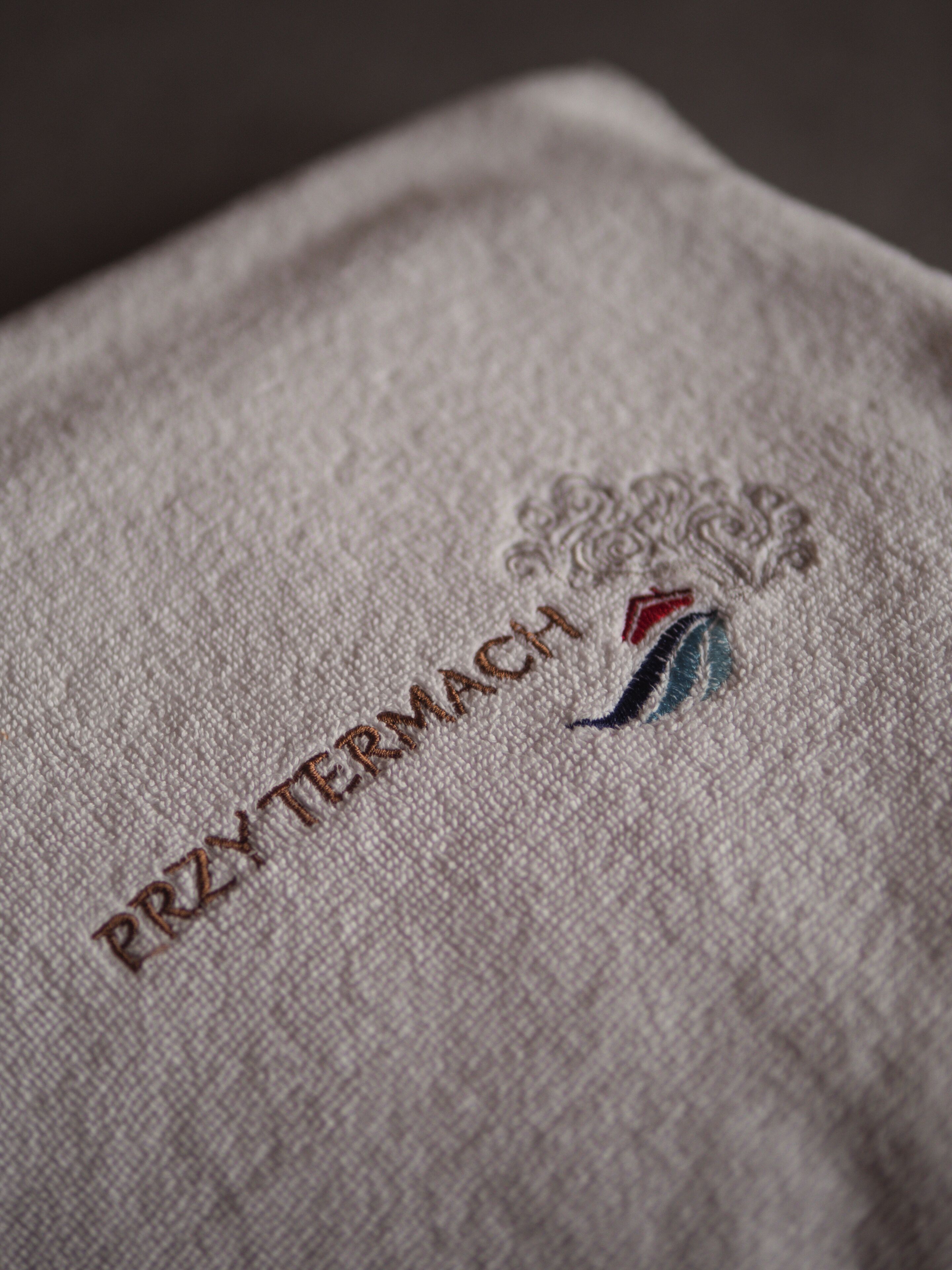 A close-up of a fabric with embroidered text and a logo.