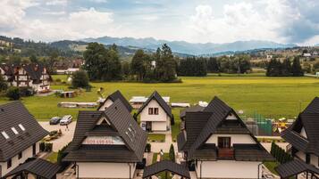 A residential area with houses, a playground, and a mountain backdrop.
