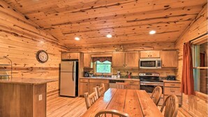 A wooden cabin interior with a kitchen, dining table, and chairs. - 6/5 Valley View! Close to Helen! Near Hiking & Wineries (Clarkesville)
