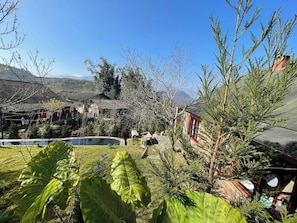 A residential area with a swimming pool, houses, and a mountainous backdrop.