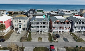 A coastal residential area with multi-story buildings, a parking lot, and a view of the ocean. - 5BR Kure Beach Condo w Elevator, Ocean Views & Walk to Beach (Kure Beach)