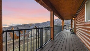 En træterrasse med udsigt over et bjerglandskab.