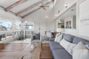 A spacious living area with a gray sofa, wooden coffee table, and a ceiling fan. - Coastal Bungalow Retreat,  Bikes & Spacious Sun Deck – Minutes to the Beach (Inlet Beach)