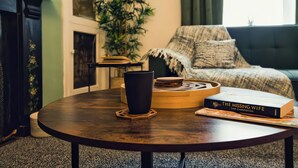 Una sala de estar acogedora con una mesa redonda de madera, un libro titulado 