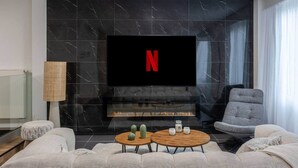 A modern living room with a fireplace, a flat-screen TV mounted above it, and a comfortable seating area with sofas and a coffee table. - To complete (Reims)
