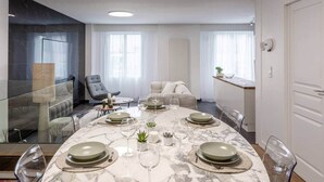 A modern dining room with a marble table set for four, surrounded by comfortable seating. - To complete (Reims)
