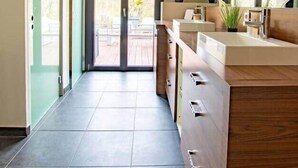 A modern bathroom with a wooden vanity, a large mirror, and potted plants. - Loft Détente Fun Champagne Experience (Isles-sur-Suippe)