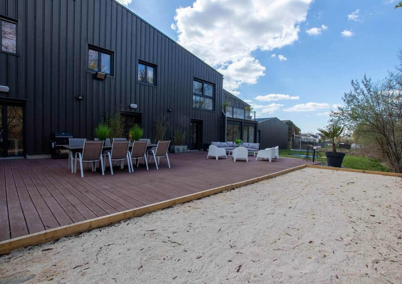 En moderne bygning med en patio og udemøbler samt en træterrasse.