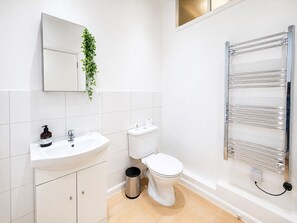 Ein modernes Badezimmer mit Waschbecken, Toilette und Handtuchhalter.