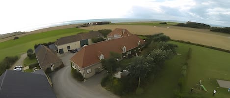 A residential area with houses, a road, and a view of the sea.