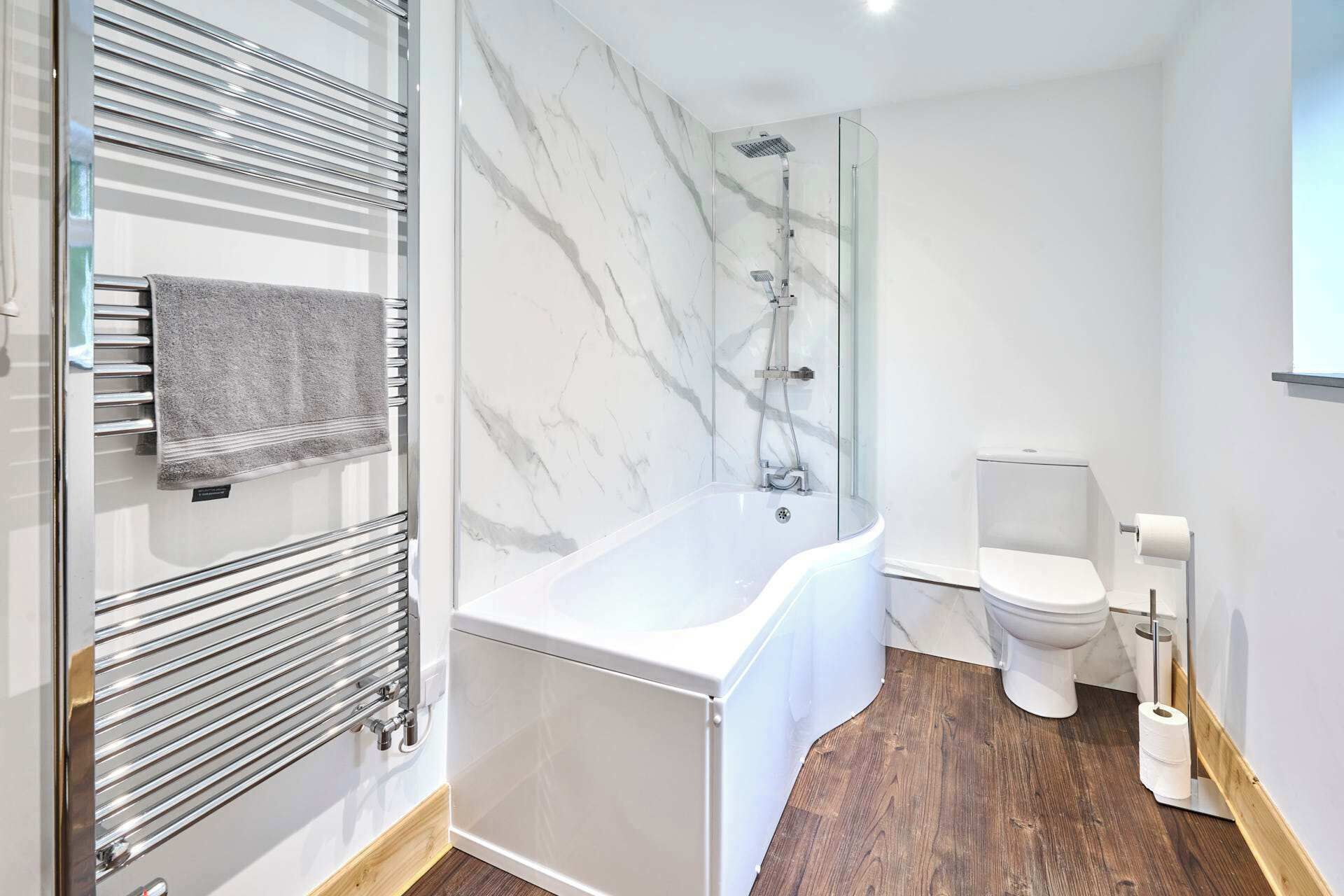 Et moderne badeværelse med et fristående badekar, en glasafskærmet brusekabine og et toilet.