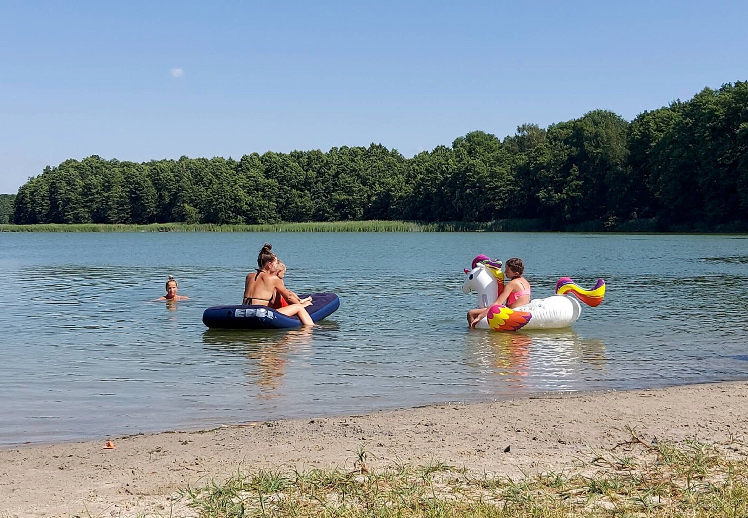 Un lac où l’on voit des gens sur des bouées gonflables.