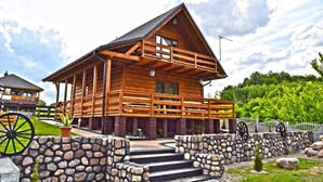 A wooden cabin with a balcony, stone steps, and a rustic exterior. - Large House With Private Garden, Right on the Lake (Lubrza)
