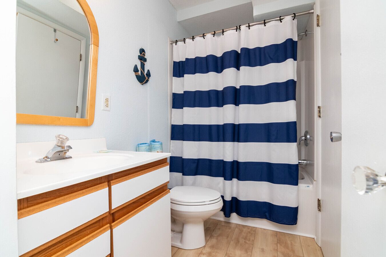 Un baño con lavamanos blanco, encimera de madera y retrete blanco.