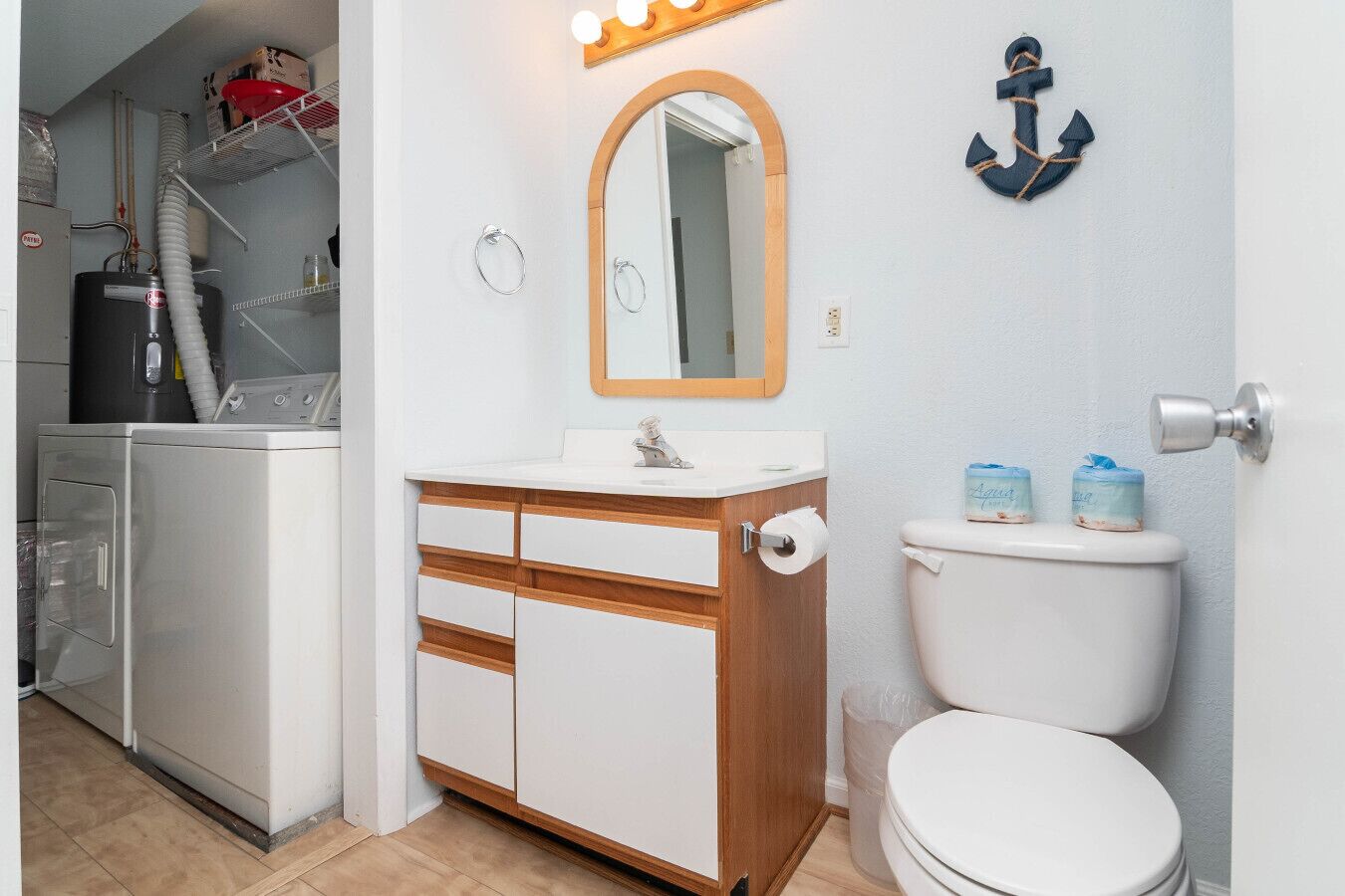 Une petite salle de bain avec un lavabo blanc, un meuble-lavabo en bois et des toilettes.