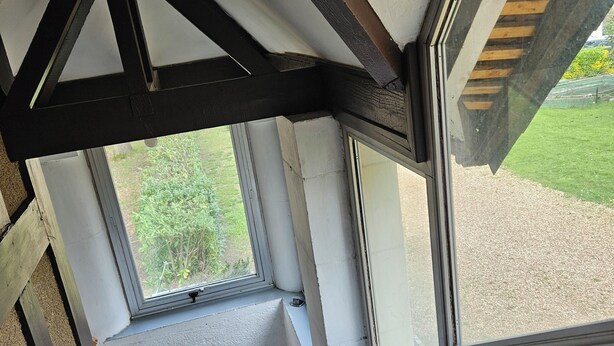 A staircase with a view of a garden through a window.